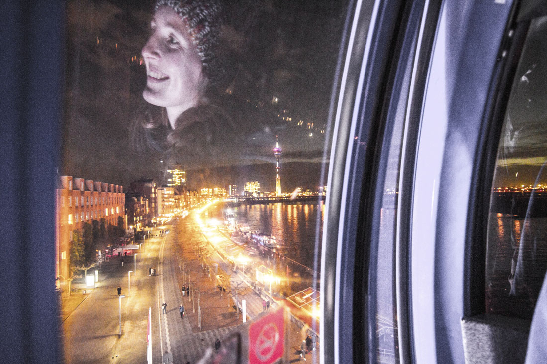 Reflectie van Manouk in het raam van het reuzenrad in Dusseldorf