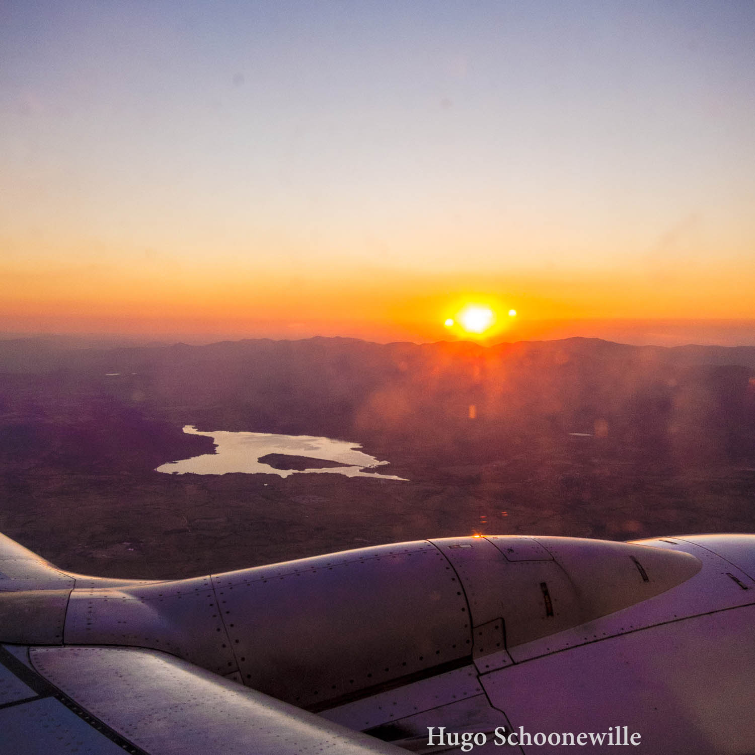 Foto van een zonsondergang uit een vliegtuig.