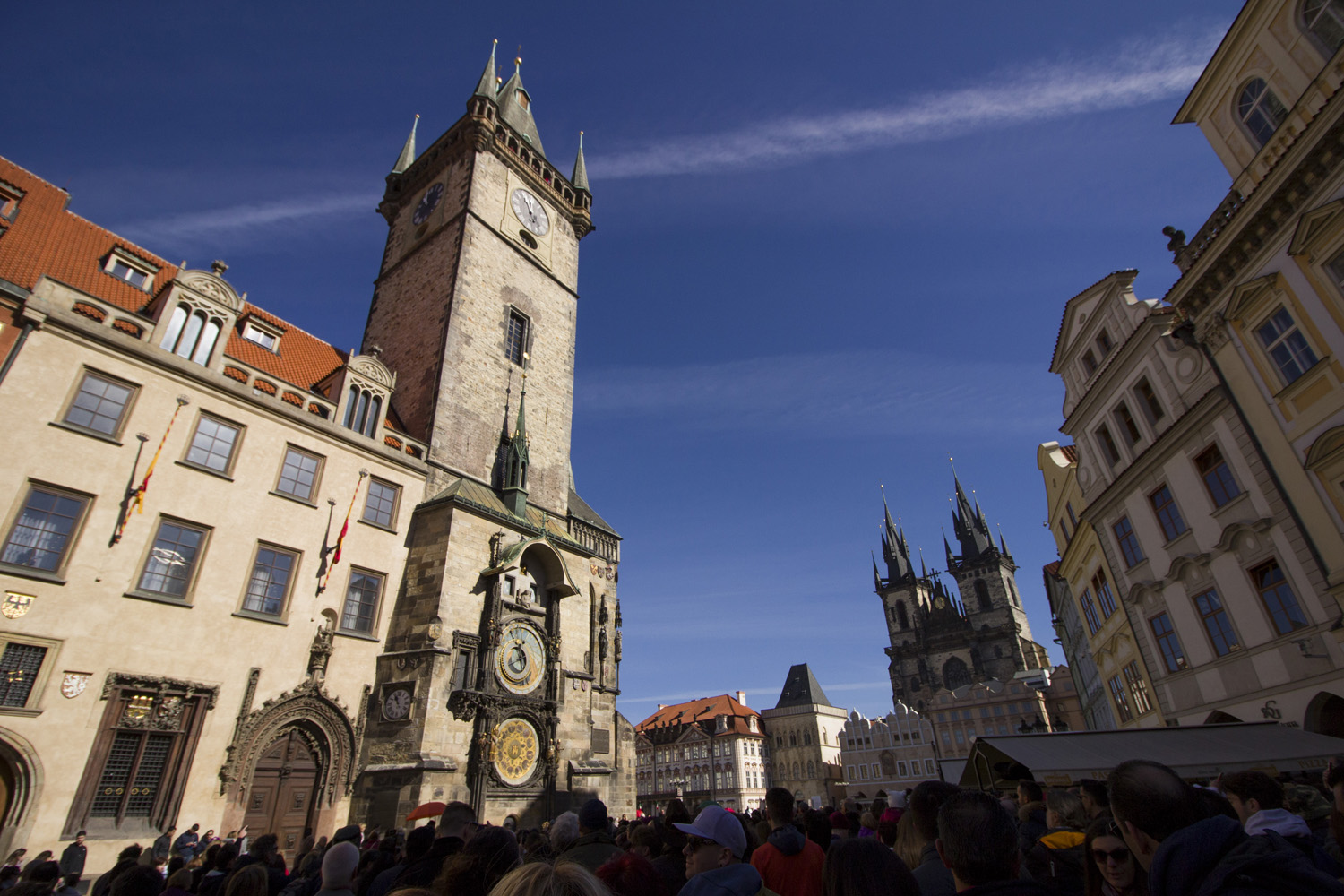 Wat te doen in Praag: de astronomische klok op de toren op het centrale plein van Praag met een groep mensen ervoor.