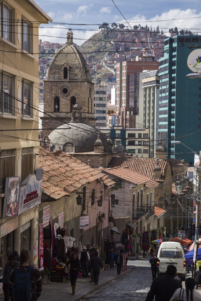 Aflopend straatje in La Paz, vol terracotta huizen en met bergen op de achtergrond.