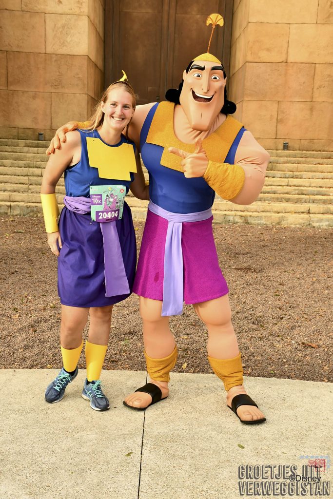 Meisje verkleed als Kronk tijdens hardloopwedstrijd in Disneyland Parijs samen met het personage Kronk op de foto.