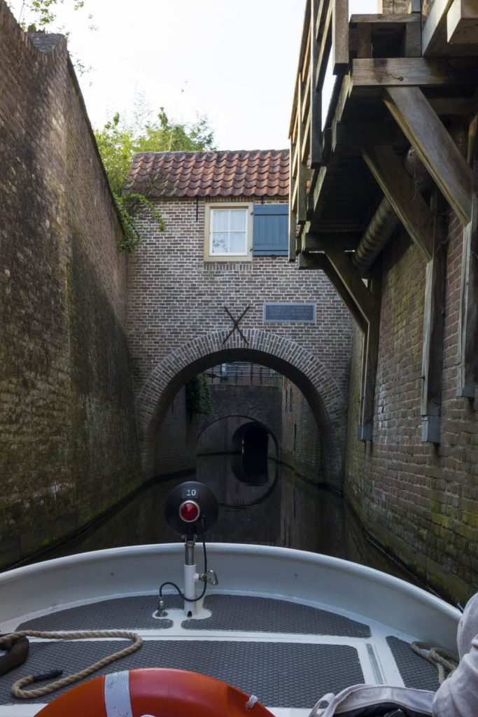 Een brug in Den Bosch gezien vanaf de Binnendieze. Je kunt over de Binnendieze varen met een bootje met gids.