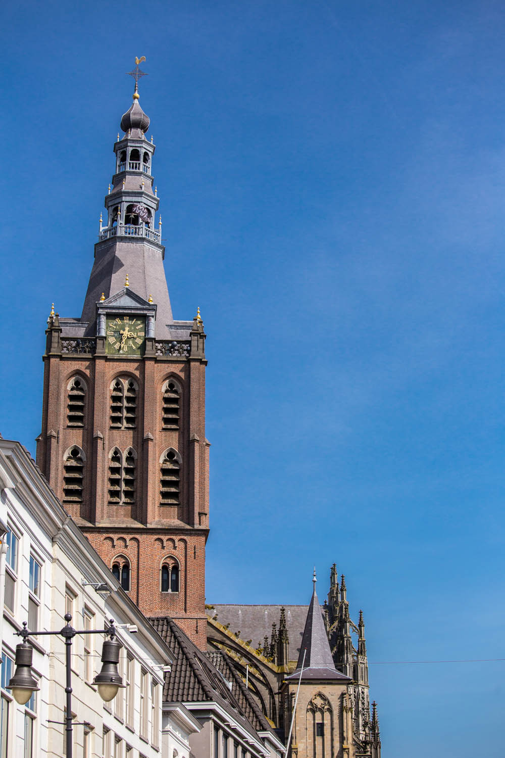 Toren van de Sint-Janskathedraal tegen een blauwe lucht