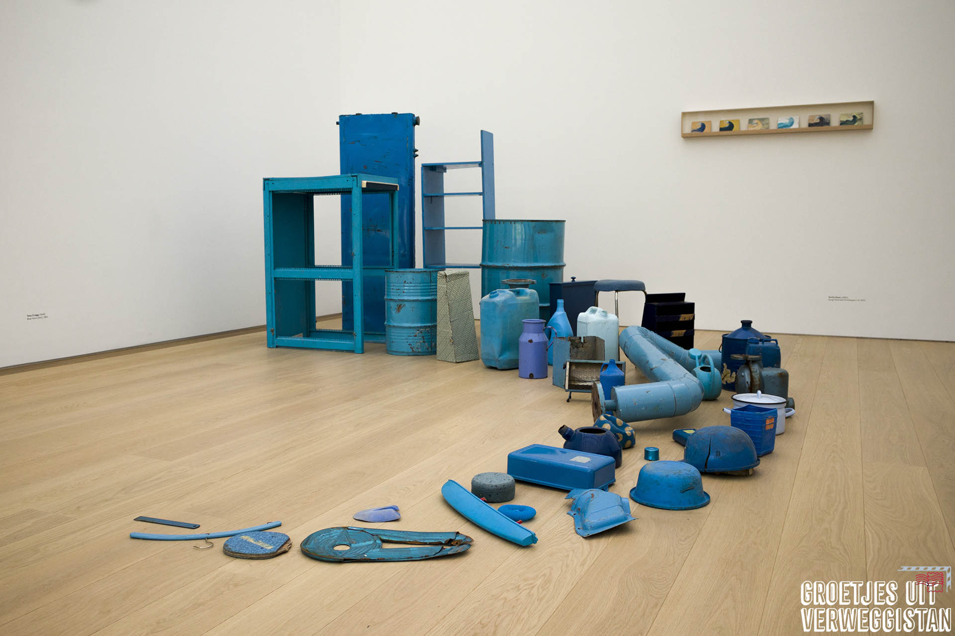 Een rij gebruiksvoorwerpen die blauw zijn gemaakt: kunstwerk van Tony Cragg,
