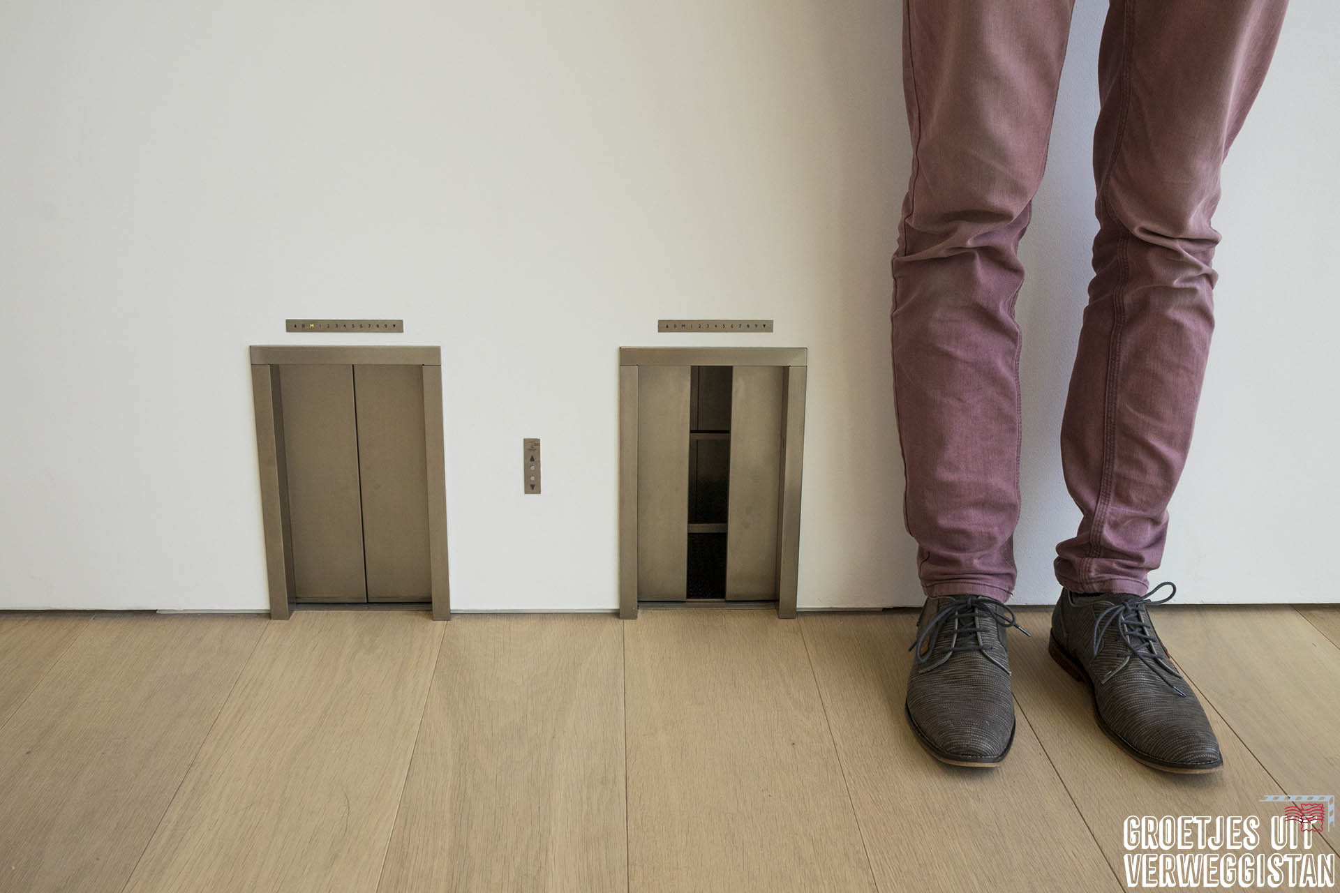 Kunstwerk van Maurizio Cattelan: twee kleine liften op enkelhoogte waarvan de deuren open en dicht gaan alsof ze echt werken.