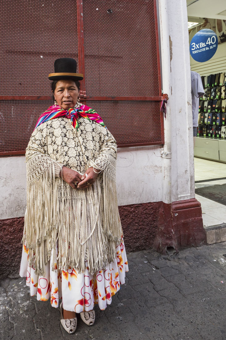Mevrouw in Bolivia in lange jurk met franje en typische zwarte bolhoed