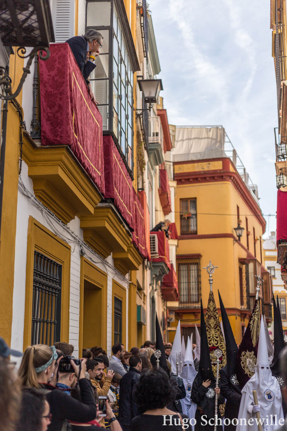 Paso in de smalle straatjes van Sevilla met mensen op de balkons die kijken
