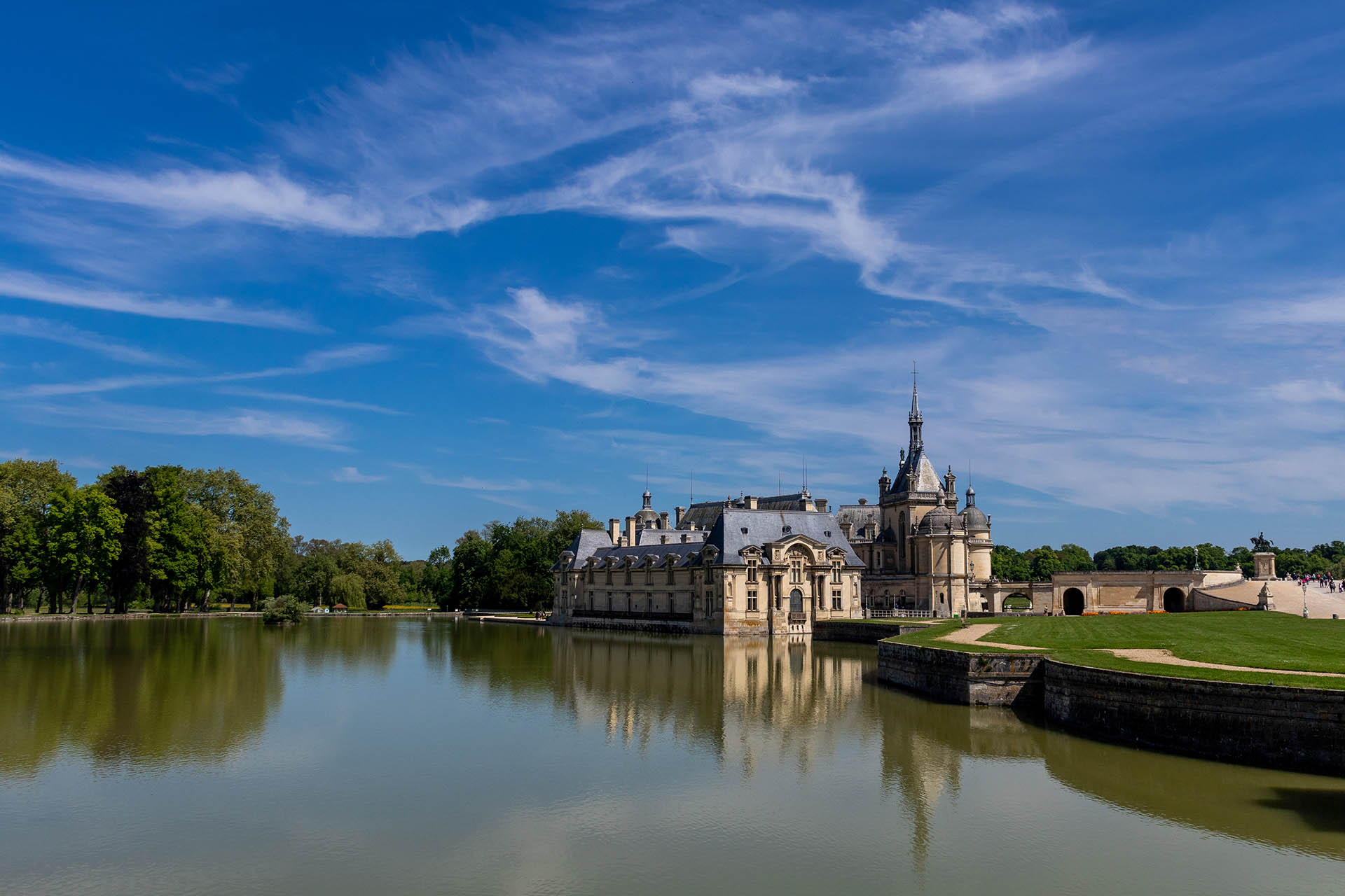 Kasteel van Chantilly met het water ervoor en een blauwe wolkenlucht