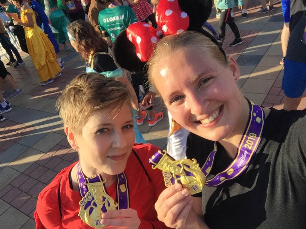 Finishfoto met twee medailles met Rapunzel na de 10 kilometer door Disney.