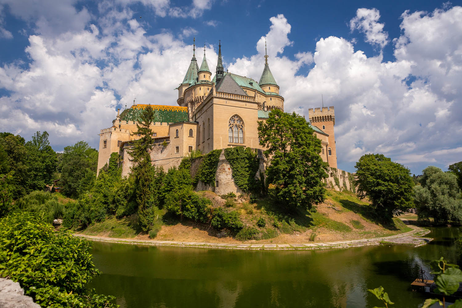 Het sprookjesachtige kasteel Bojnice in Slowakije met slotgracht, torentjes en blauwe lucht
