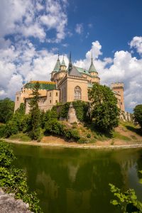 Het kasteel van Bojnice met de slotgracht, torentjes en de blauwe lucht