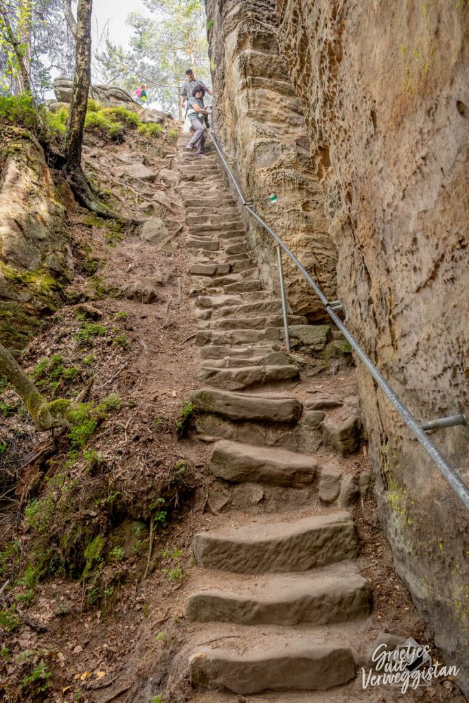 Steile trap uitgehakt in de rotsen met een leuning.