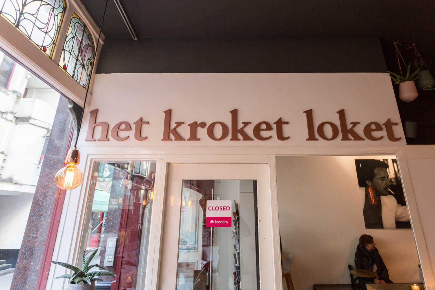 Het Kroket Loket in letters op de muur boven de deur binnenin het restaurant in Den Haag.