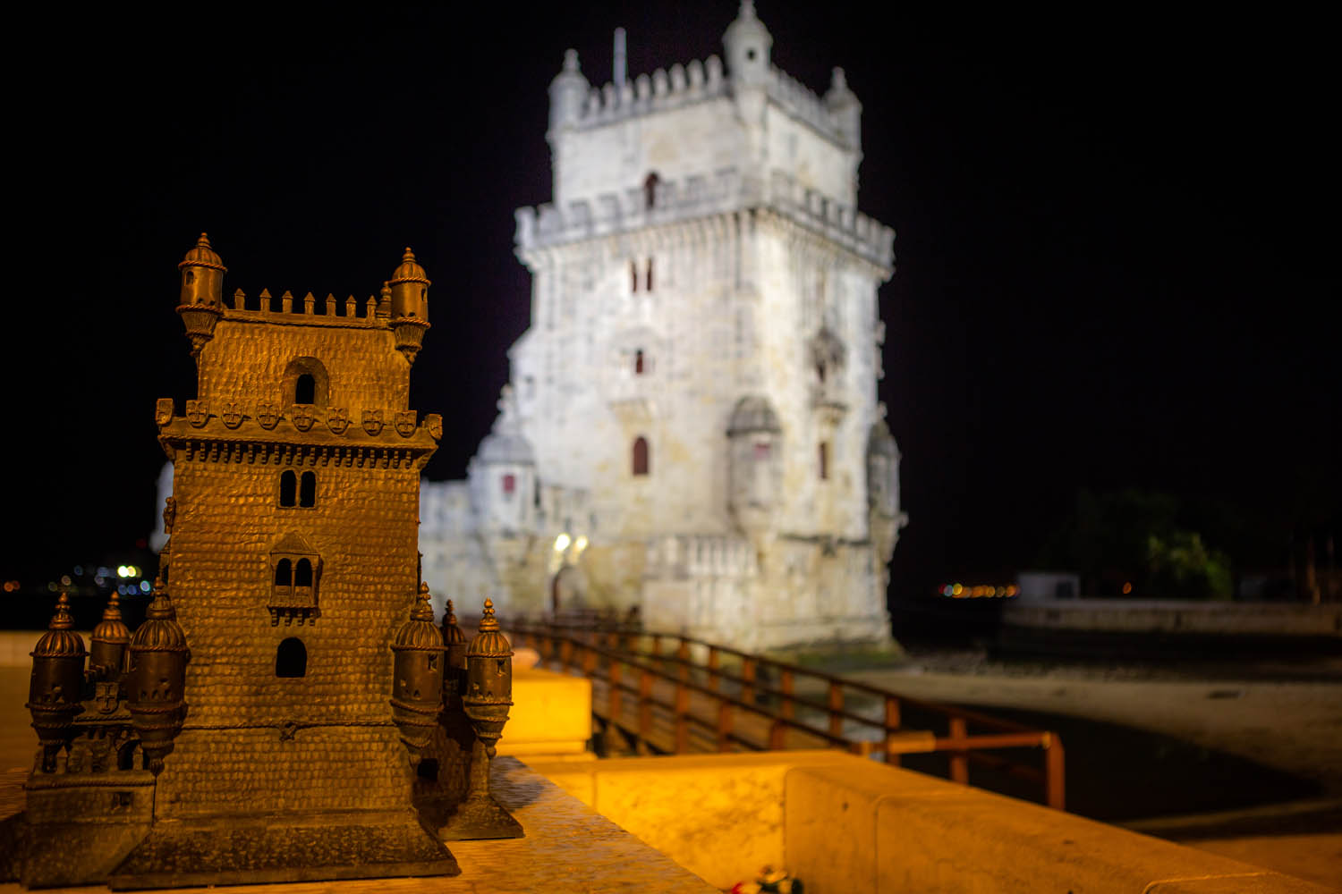 Torre de Belém, goed verlicht in het donker. Op de voorgrond een klein model van de toren, zodat je kan voelen hoe hij eruit ziet.