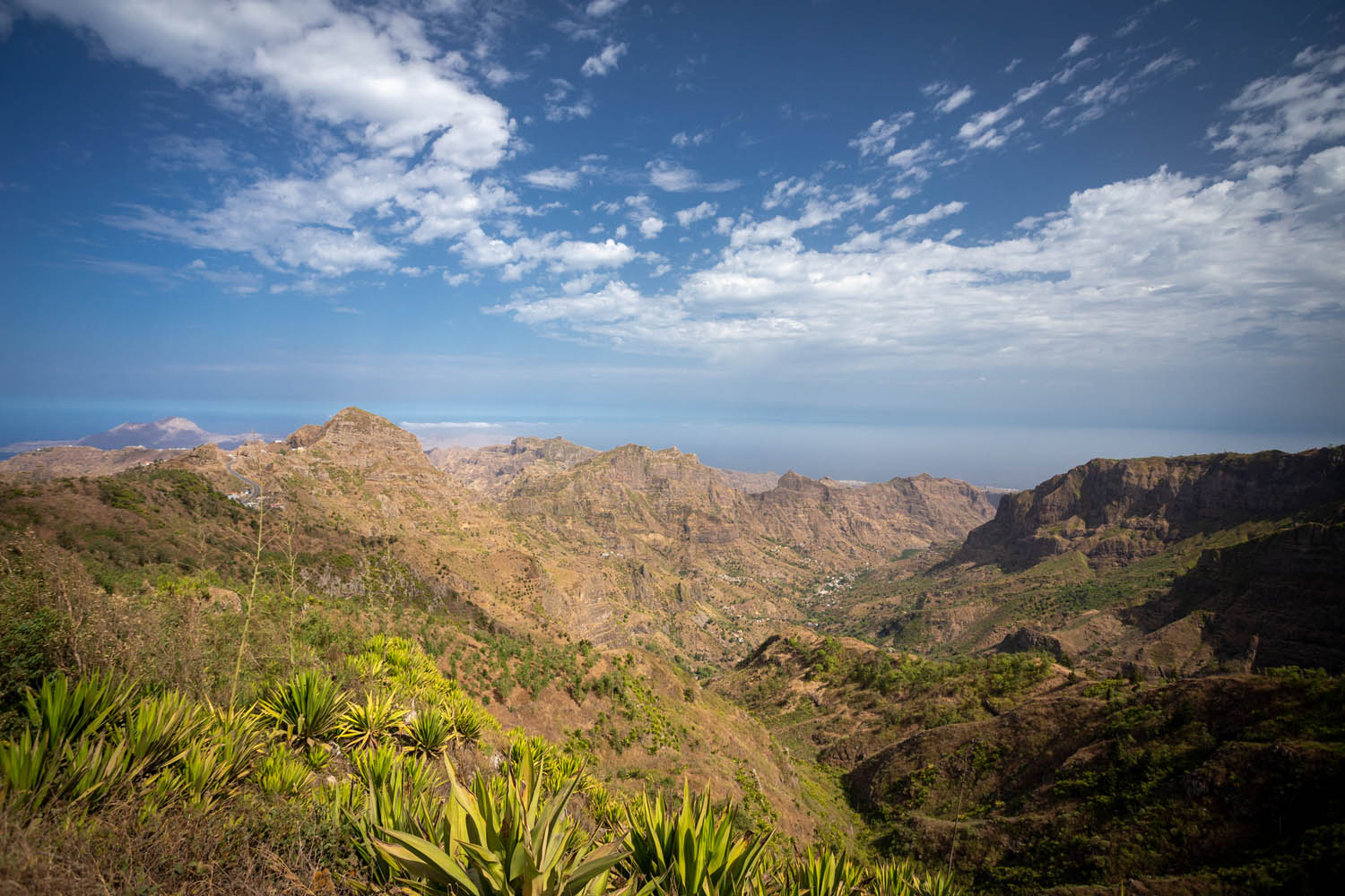 Uitzicht vanaf de Eixo Oriental Trail over  bergen en in de verte de zee en blauwe lucht van Santiago in  Kaapverdië.
