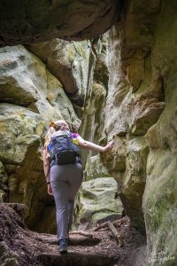 Manouk wandelt tussen smalle rotsspleten op de Mullerthal Trail