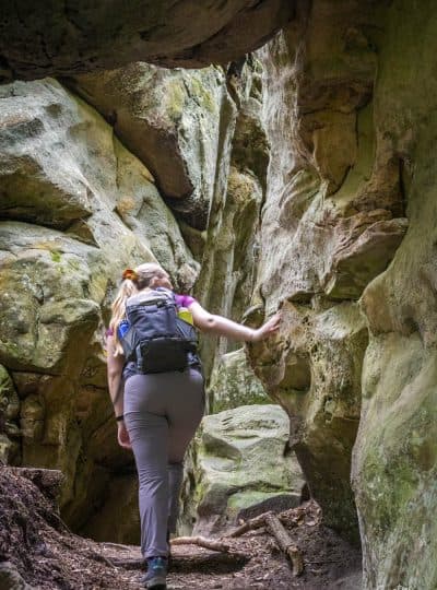 Manouk wandelt tussen smalle rotsspleten op de Mullerthal Trail