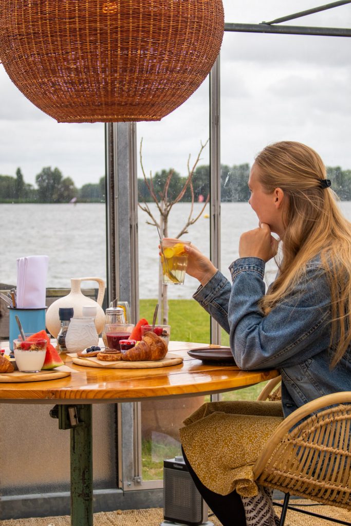 Manouk met een glas thee tijdens het ontbijt in een kas bij Brasserie Buitenhuis