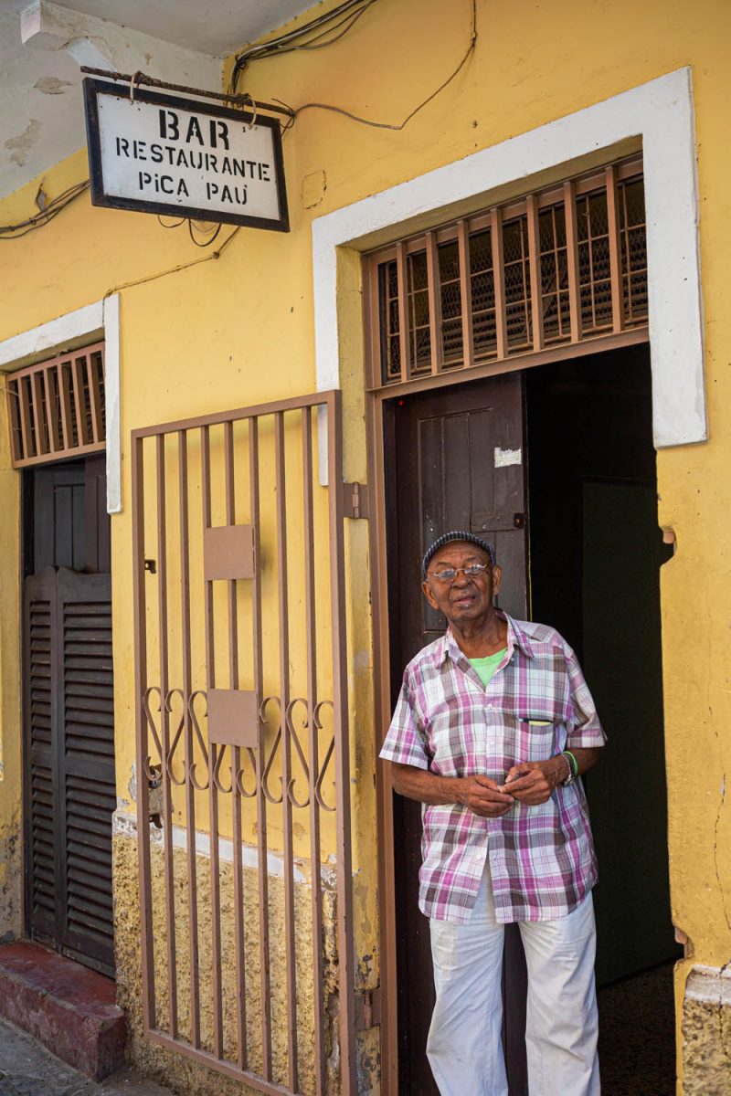 De eigenaar van restaurant Pica Pau in de deuropening van zijn restaurant in Mindelo