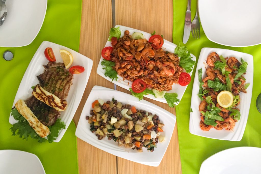 Tafel met groene tafelkleedjes en vier schalen eten bij Marezita Gourmet in Mindelo