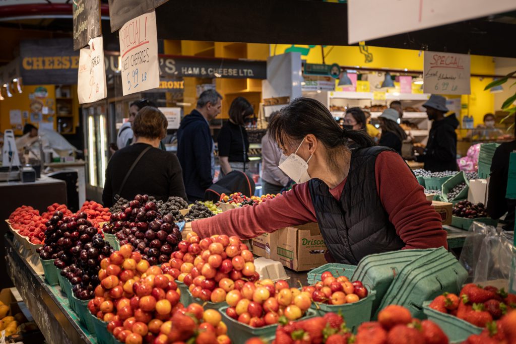 Vrouw pakt fruit voor een klant op Granville Island Public Market, wat te doen in Vancouver