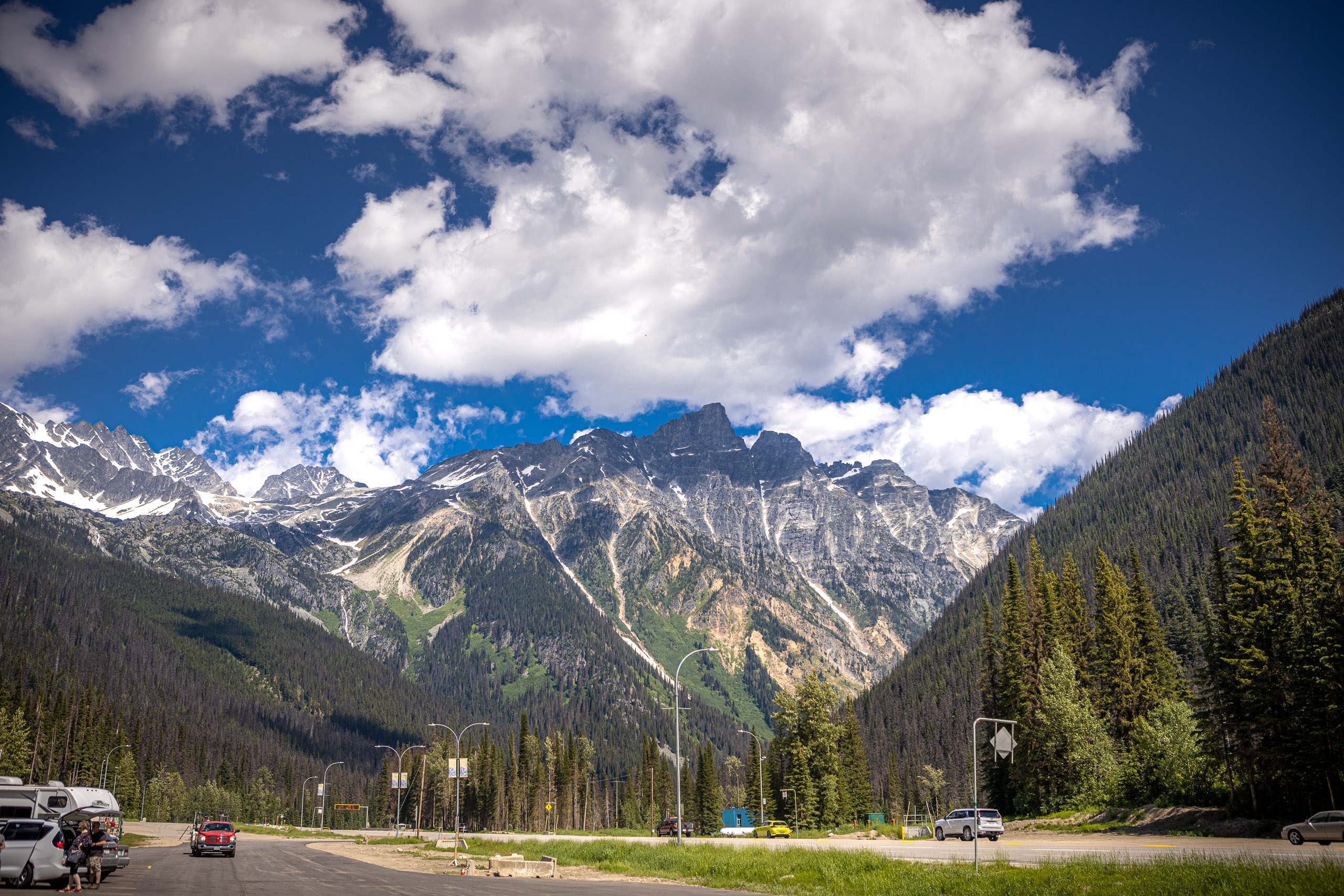 Mooie hoge bergen langs de snelweg in Canada met blauwe wolkenlucht. Wat zijn de kosten van een rondreis door Canada met camper?