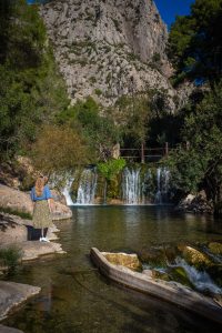 Manouk met groene rok en blauwe blouse kijkt naar watervallen van Algar
