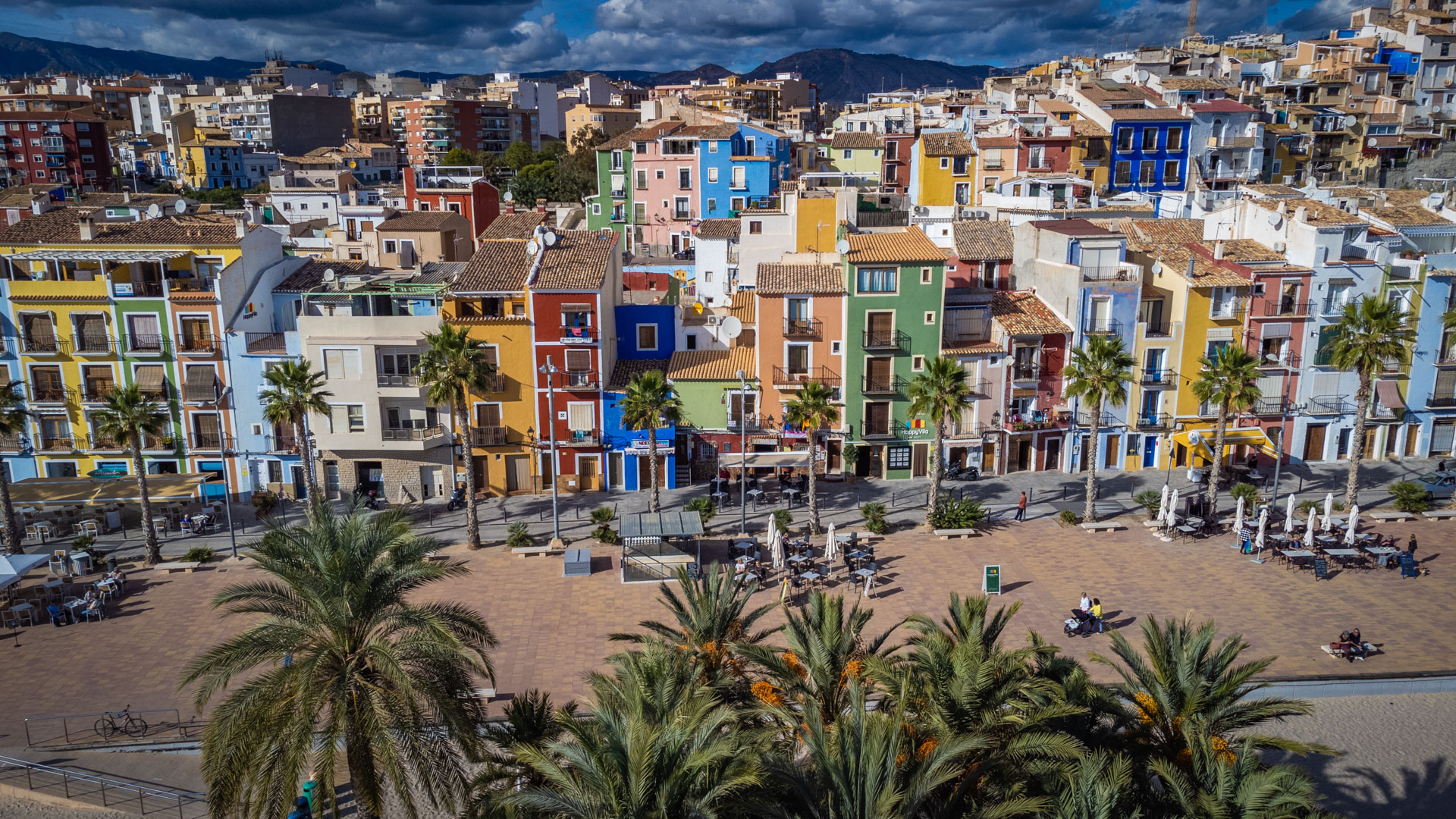 Gekleurde vissershuizen van Villajoyosa aan het strand aan de Costa Blanca met palmbomen ervoor