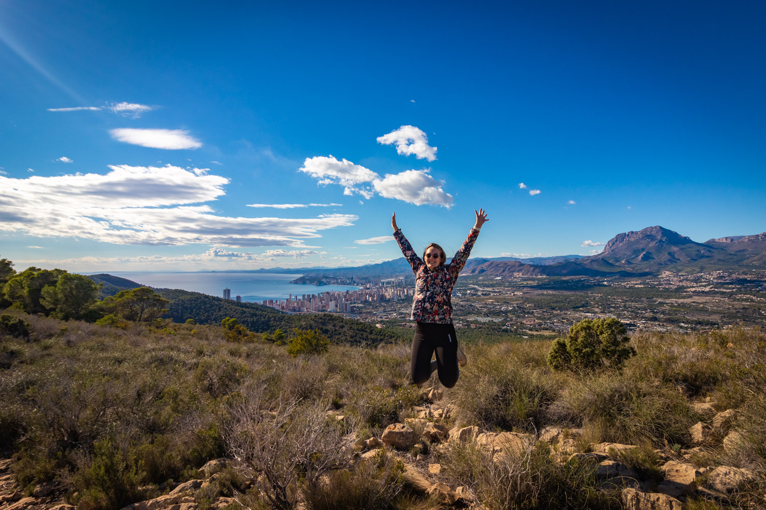 Manouk springt in de lucht in nationaal park Serra Gelada met Benidorm op de achtergrond