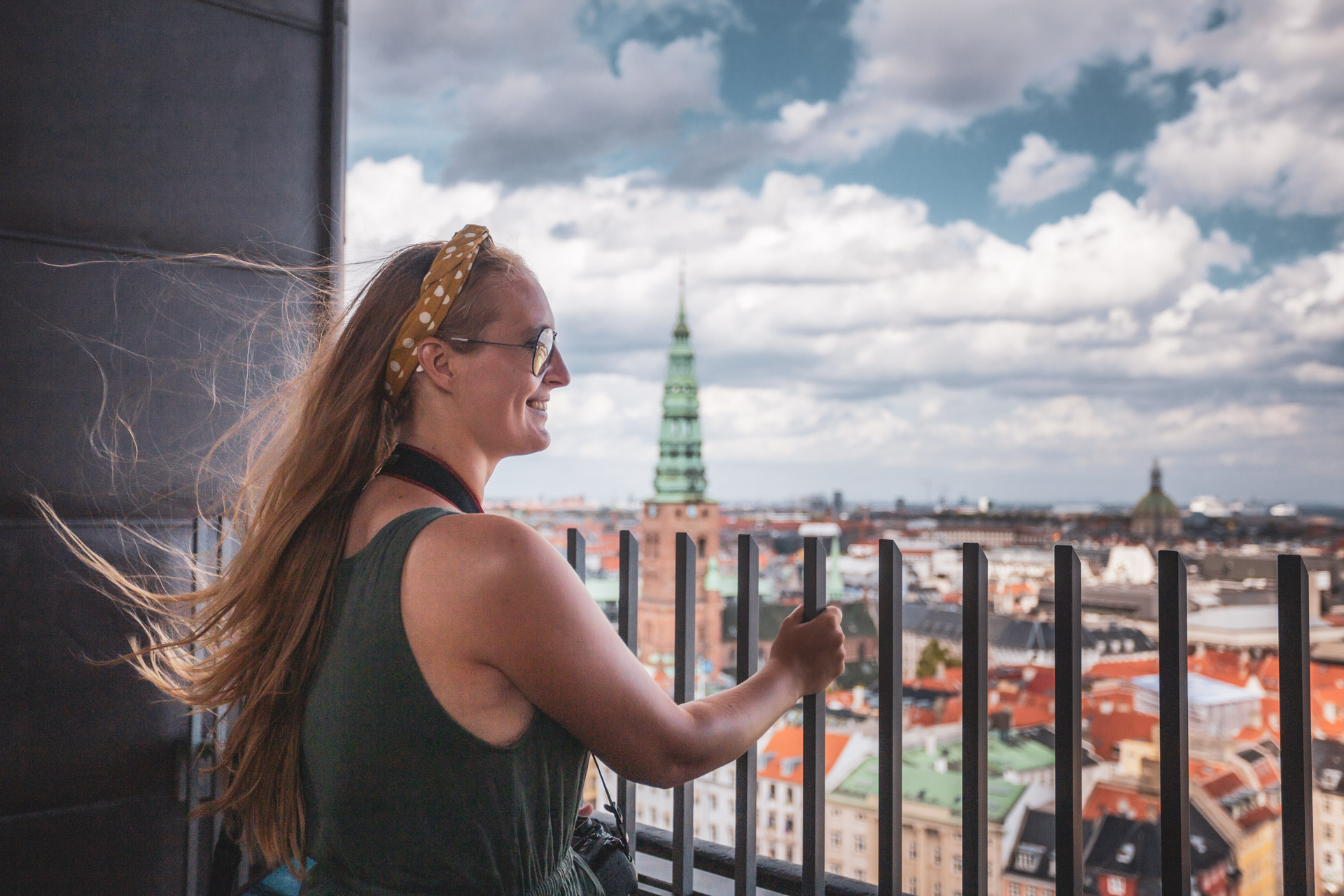 Manouk kijkt over een hek van de toren van Christiansborg uit over de stad Kopenhagen