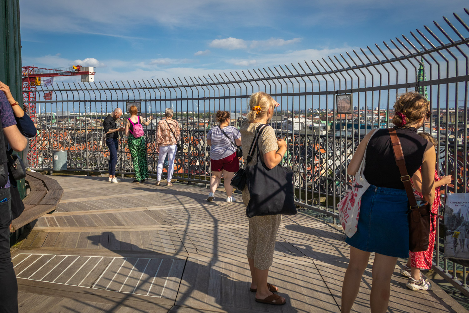 Mensen op het uitkijkplatform van de Rundetaarn in Kopenhagen met een hek eromheen