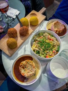 Gehaktballen op een plank, stamppot op borden en een salade in het midden bij Balls & Glory in Antwerpen