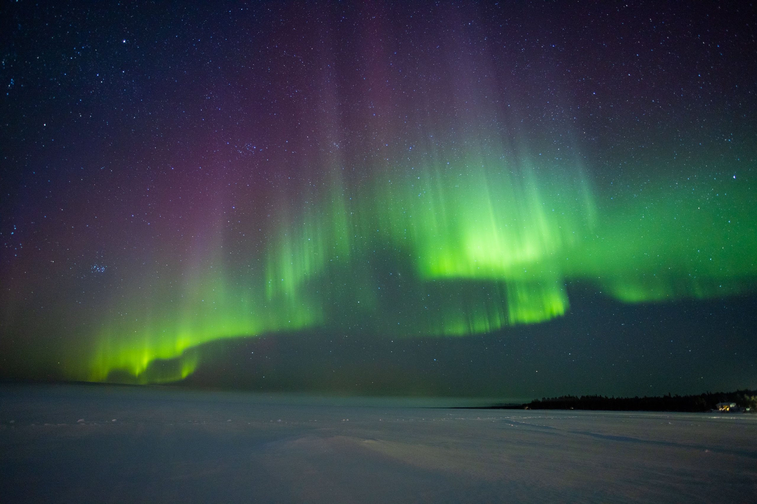 Noorderlicht over een meer in Rovaniemi, met groen en paar licht