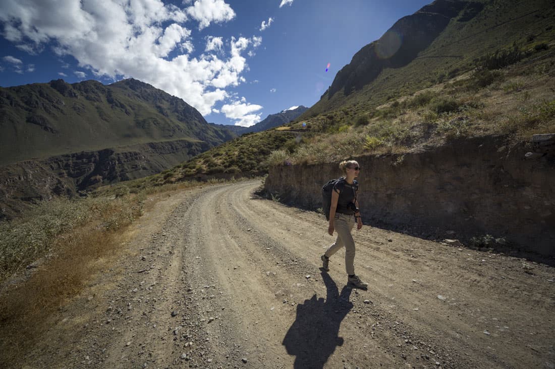 Manouk loopt over de onverharde weg richting Malata in de Colca Canyon in de zon.