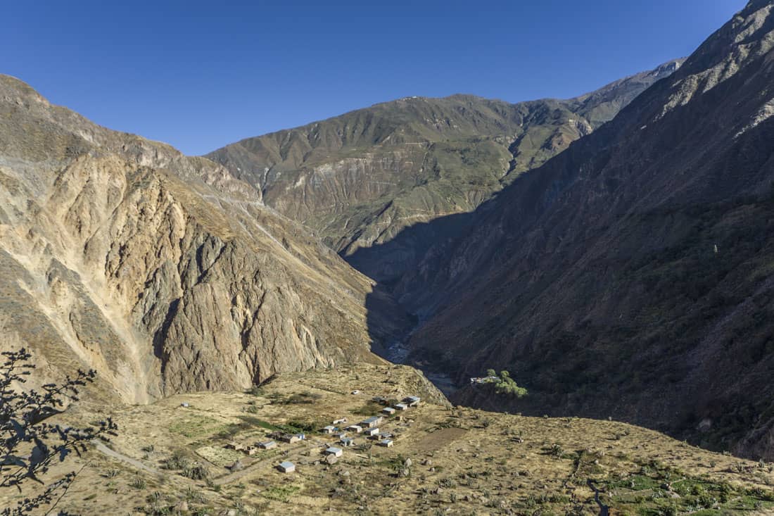 Sangalle in het dal van de kloof Colca Canyon met de zigzagweg naar Cabanaconde tegen de wand te zien
