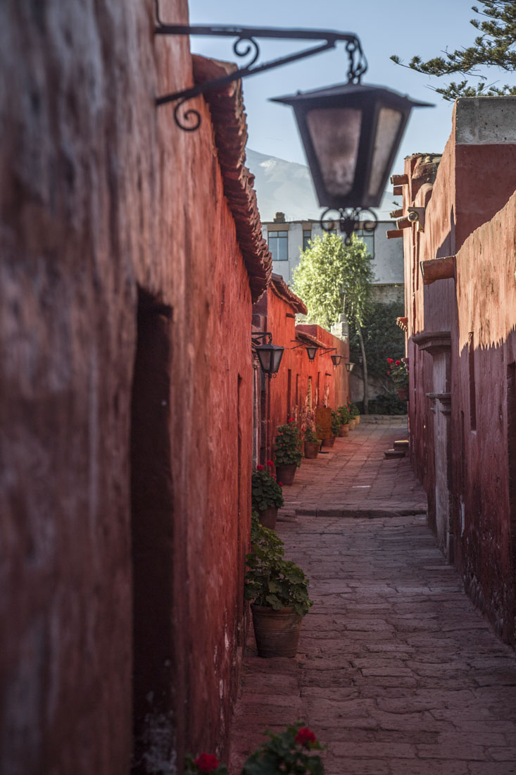 Smal straatje omringd met rode muren in het Santa Catalina klooster in Arequipa